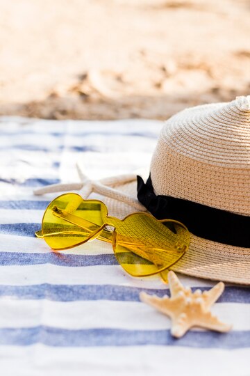 Solhatt, briller på en strand, oliveselect solbeskyttelse